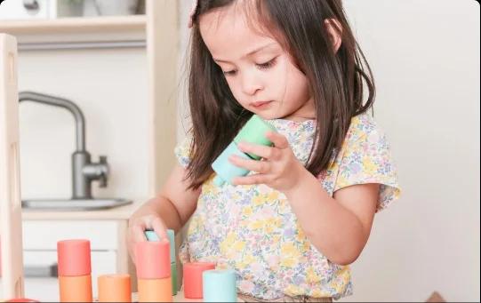 Child with Lovevery stacking toy