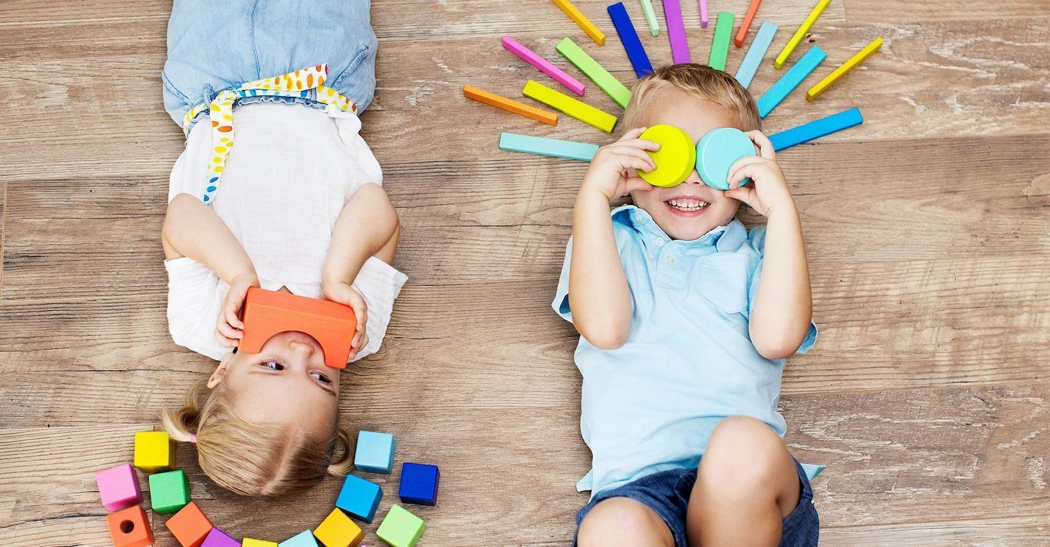 Two children laying with blocks from The Block Set by Lovevery