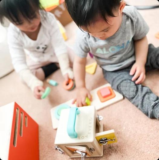 Two kids playing with wooden toys