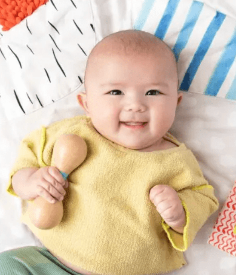 baby with wooden rattle